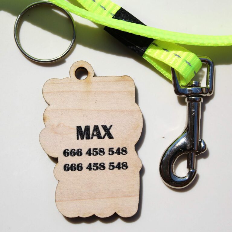 Parte trasera de una placa para perros. Impresión del nombre y telefonos de contacto